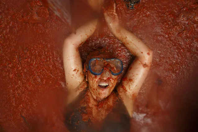 Revellers enjoy the atmosphere in tomato pulp while participating the annual Tomatina festival on August 30, 2017 in Bunol, Spain. An estimated 22,000 people threw 150 tons of ripe tomatoes in the world's biggest tomato fight held annually in this Spanish Mediterranean town.  (Photo by Pablo Blazquez Dominguez/Getty Images)
