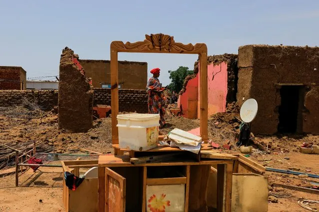 A woman collects her belongings after sustaining water damage to her house during floods in Al-Managil locality, in Jazeera State, Sudan on August 23, 2022. (Photo by Mohamed Nureldin Abdallah/Reuters)