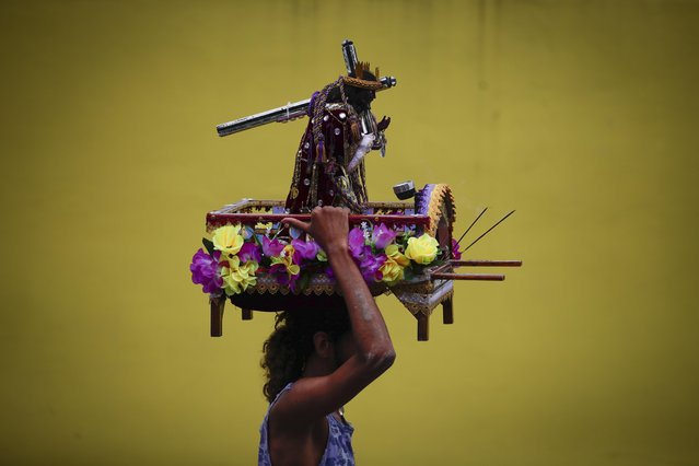 A pilgrim carries an image of the Black Christ during the penitence walk to the church of Saint Phillipe to pay devotion to the “Cristo Negro de Portobelo” or Black Christ of Portobelo in Portobelo, Panama in Portobelo, Panama on October 21, 2023. Thousands of devotees visit the Black Christ every year from all parts of the country. (Photo by Bienvenido Velasco/EPA/EFE)