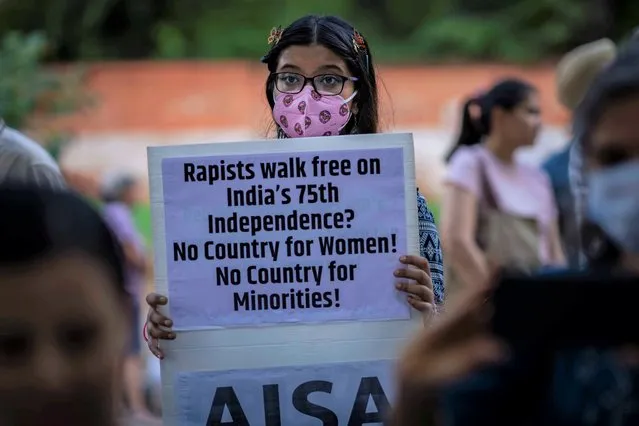 A protestor holds a placard against the remission of sentence by the government to convicts of a gang rape of a Muslim woman, in New Delhi, India, Saturday, August 27, 2022. Hundreds of people on Saturday held demonstrations in several parts of India to protest a recent government decision to free 11 men who had been jailed for life for gang raping a Muslim woman during India’s devastating 2002 religious riots. (Photo by Altaf Qadri/AP Photo)