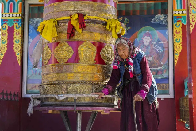 An elderly Ladakhi woman spins a prayer wheel, locally known as Mani, on the outskirts of Leh, Ladakh, India, Thursday, September 15, 2022. (Photo by Mukhtar Khan/AP Photo)