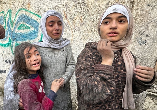Children react following an Israeli air strike on Palestinian houses, amid the ongoing conflict between Israel and the Palestinian Islamist group Hamas, in Rafah in the southern Gaza Strip on December 12, 2023. (Photo by Fadi Shana/Reuters)