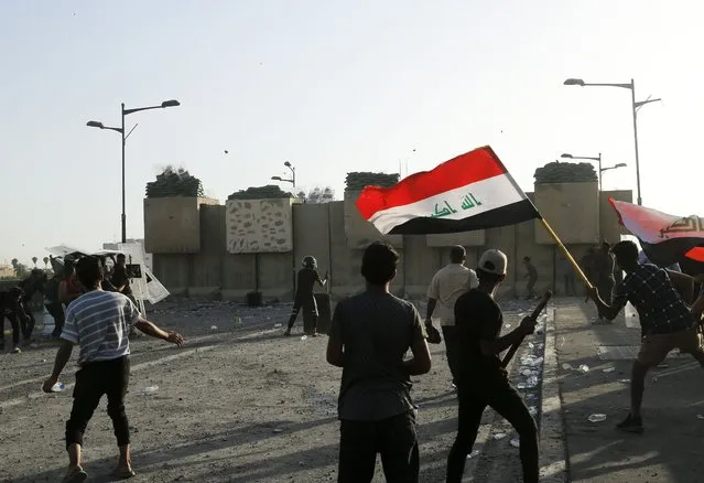 Anti-government protesters throw stones towards security forces during a demonstration in Tahrir Square in Baghdad, Iraq, Wednesday, September 28, 2022. (Photo by Hadi Mizban/AP Photo)