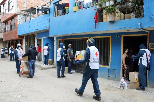 Members of the Colombian Red Cross deliver food aid to the inhabitants of the El Amparo neighborhood in the locality of Kennedy, in Bogota, Colombia, 10 June 2020. A test day for the coronavirus was held on 10 June in the locality of Kennedy in the south of Bogota. The locality remains in total quarantine due to the high number of infections present. (Photo by Carlos Ortega/EPA/EFE/Rex Features/Shutterstock)