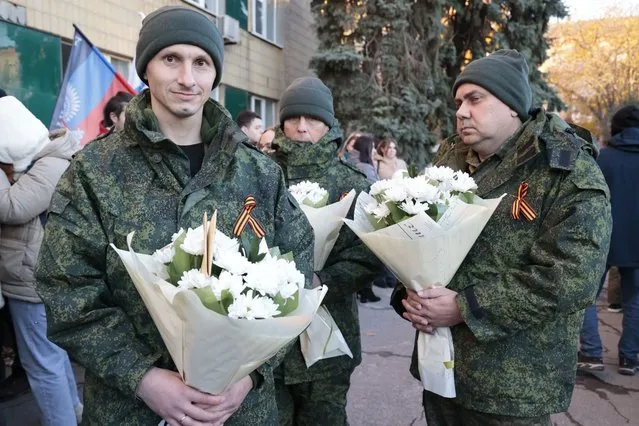Two liberated soldiers hold bunches of flowers during a meeting after the exchange of servicemen of the Donetsk People's Republic and the Lugansk People's Republic who were imprisoned, in Amvrosiivka, Donetsk People's Republic, eastern Ukraine, Tuesday, November 1, 2022. Russia and Ukraine on Saturday made an exchange of prisoners, which took place according to the formula “50 to 50”. (Photo by Alexei Alexandrov/AP Photo)