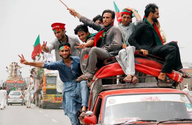 Supporters of the Pakistan Tehreek-e-Insaf party wave flags as they start an anti-government demonstration in Peshawar, Pakistan, August 7, 2016. (Photo by Fayaz Aziz/Reuters)
