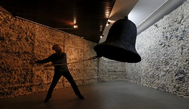 Russian artist Vasily Slonov pulls the rope of a cotton wool bell during the performance of the "Russian Alarm Bell", dedicated to prisoners of GULAG who often wore coats and jackets made of cotton wool, during the 11th Krasnoyarsk Museum Biennale at the Krasnoyarsk Museum Centre in Siberia, Russia, September 30, 2015. (Photo by Ilya Naymushin/Reuters)