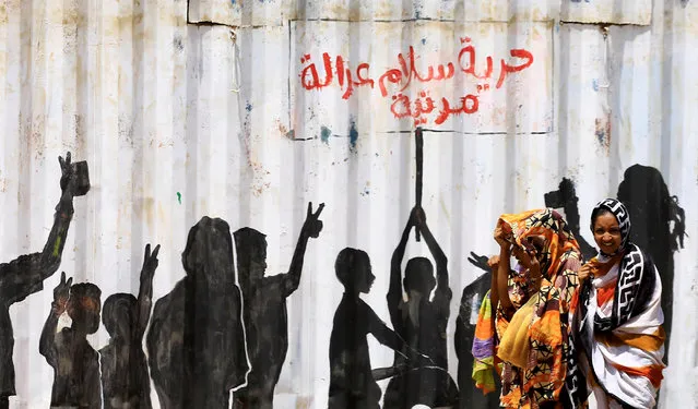 Civilians walk past graffiti reading in Arabic “Freedom, Peace, Justice and Civilian” in the Burri district of Khartoum, Khartoum, Sudan, July 10, 2019. (Photo by Mohamed Nureldin Abdallah/Reuters)