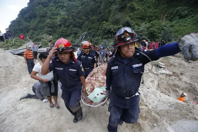 Rescue workers carry a body away from the site of a landslide in Santa Catarina Pinula, on the outskirts of Guatemala City, Friday, October 2, 2015. Recent rainfall provoked the landslide, affecting dozens of homes. (Photo by Moises Castillo/AP Photo)