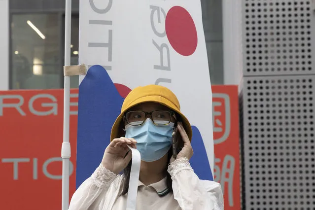 A woman wears a mask to prevent the spread of the coronavirus as she visits a weekend open air market in Beijing on Saturday, August 8, 2020. As the coronavirus outbreak comes under control in the Chinese capital, normal life is slowing returning albeit with the requisite masks. (Photo by Ng Han Guan/AP Photo)