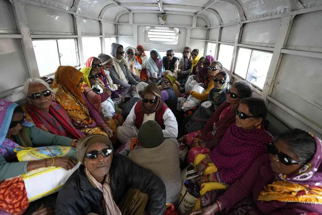 Elderly Indian villagers sit in a vehicle after being discharged from cataract surgery at an eye camp by Manohar Das Netra Chikitsalay in Prayagraj, in the northern Indian state of Uttar Pradesh, India. Friday, December 9, 2022. (Photo by Rajesh Kumar Singh/AP Photo)