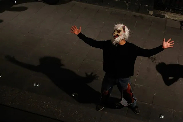 A man wearing a werewolf mask sings in an alley in downtown Mexico City, October 30, 2014. (Photo by Tomas Bravo/Reuters)