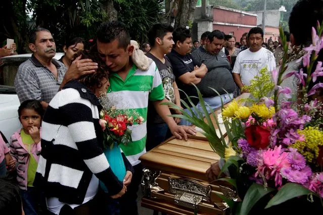 Relatives of a mudslide victim mourn next to his coffin at a cemetery, in Santa Catarina Pinula, on the outskirts of Guatemala City, October 4, 2015. (Photo by Josue Decavele/Reuters)