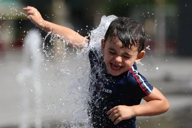 A boy cools off in a fountain in central Brussels, Belgium, August 6, 2020. (Photo by Yves Herman/Reuters)