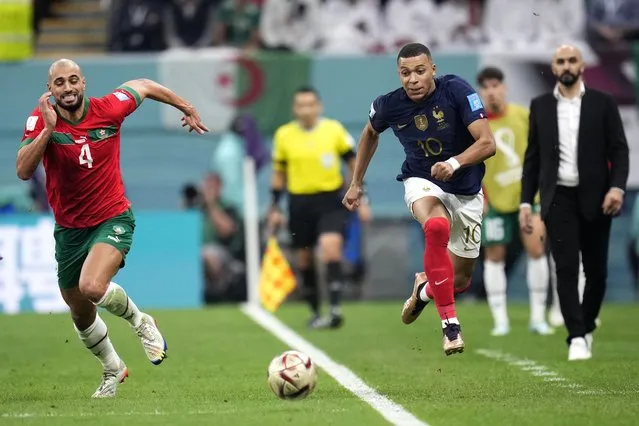 Morocco's Sofyan Amrabat, left, and France's Kylian Mbappe go for the ball during the World Cup semifinal soccer match between France and Morocco at the Al Bayt Stadium in Al Khor, Qatar, Wednesday, December 14, 2022. (Photo by Manu Fernandez/AP Photo)