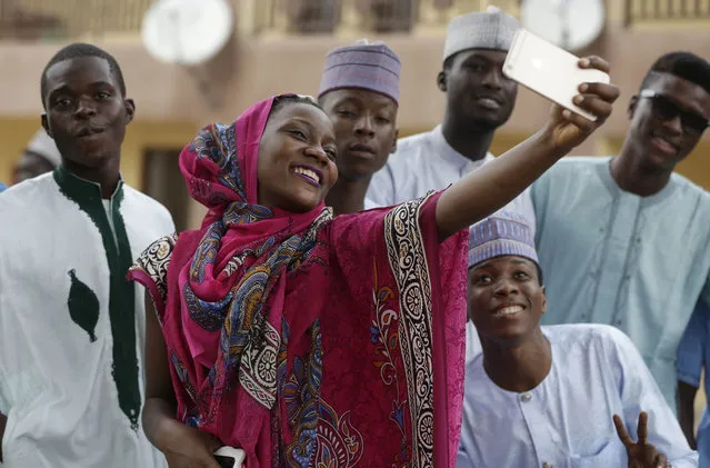 A Nigeria Muslim wpman and friends takes a selfie photo after Eid al-Adha, or Feast of Sacrifice, that commemorates the Prophet Ibrahim's faith, at the prayer ground in Lagos, Nigeria, Monday, September 12, 2016. Eid al-Adha marks the end of hajj. (Photo by Sunday Alamba/AP Photo)