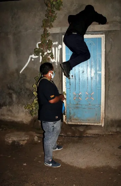 Officers of a Libyan anti-illegal immigrants unit conduct an early morning raid on migrants at hideout in Tripoli, Libya October 13, 2015. (Photo by Hani Amara/Reuters)