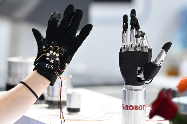 A staff member remotely controls a bionic arm using force-sensing gloves at the 2025 World Semiconductor Conference & Expo in Nanjing, in China's eastern Jiangsu province on June 20, 2025. (Photo by AFP Photo/China Stringer Network)