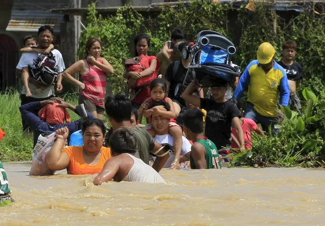 Residents wade in flood waters brought by typhoon Koppu that battered Candaba town, Pampanga province, north of Manila October 20, 2015. (Photo by Romeo Ranoco/Reuters)