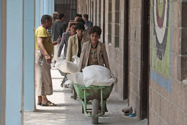 In this August 25, 2019, file photo, displaced Yemenis receive food supplies provided by the World Food Programme, at a school in Sanaa, Yemen. The World Food Program chief warned Thursday, Sept. 17, 2020, that millions of people are closer to starvation because of the deadly combination of conflict, climate change and the COVID-19 pandemic and he urged donor nations and billionaires to help feed them and ensure their survival. (Photo by Hani Mohammed/AP Photo/File)