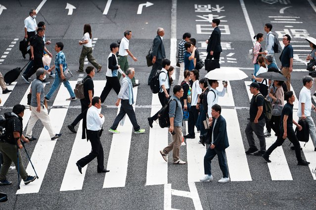 People walk along a pedestrian crossing at a shopping street Wednesday, June 4, 2025, in Tokyo. (Photo by Eugene Hoshiko/AP Photo)