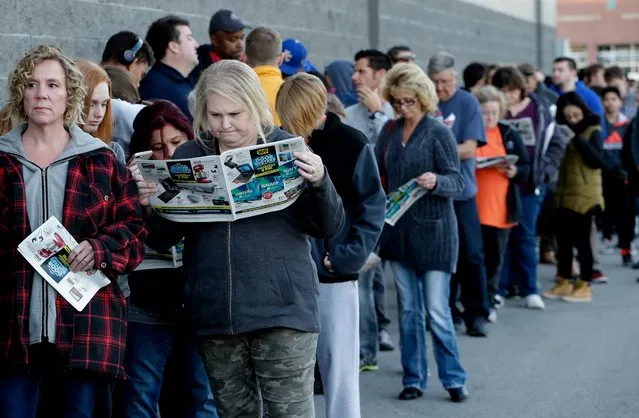 People wait in line for a Best Buy store to open for a Black Friday sale on Thanksgiving Day, Thursday, November 23, 2017, in Overland Park, Kan. Shoppers are hitting the stores on Thanksgiving as retailers under pressure look for ways to poach shoppers from their rivals. (Photo by Charlie Riedel/AP Photo)
