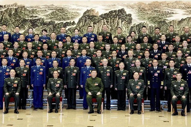 In this photo released by Xinhua News Agency, Chinese President Xi Jinping, bottom center, also general secretary of the Communist Party of China Central Committee and chairman of the Central Military Commission, poses for a group photo with deputies from the delegation of the People's Liberation Army (PLA) and the People's Armed Police Force before attending a plenary meeting of the delegation during the first session of the 14th National People's Congress (NPC) in Beijing, on Wednesday, March 8, 2023. Xi has called for “more quickly elevating the armed forces to world-class standards”, in a speech coming days after he warned the country was threatened by a U.S.-led campaign of “containment, encirclement and suppression of China”. (Photo by Li Gang/Xinhua via AP Photo)