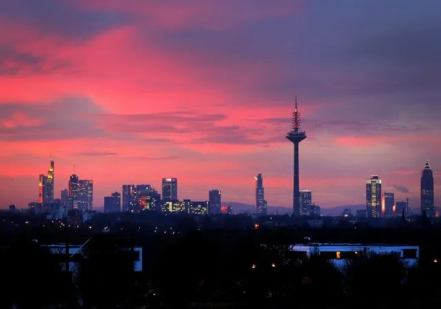 Colorful clouds hang over the skyline as the sun rises in Frankfurt, Germany, Tuesday, Nov. 22, 2016. (Photo by Michael Probst/AP Photo)