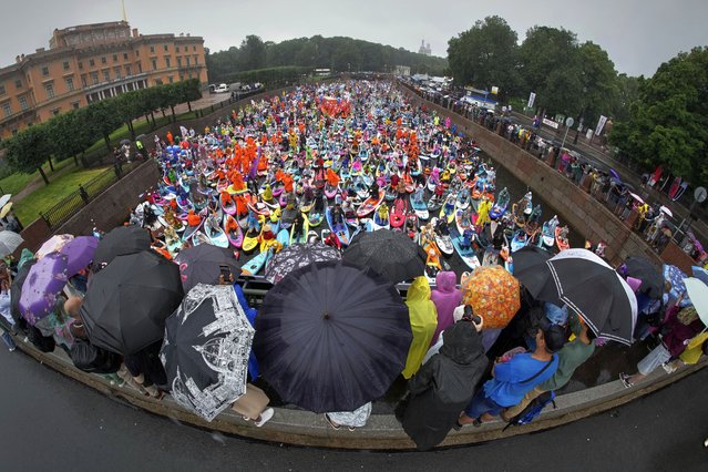 People steer their stand-up paddle (SUP) boards during rainfall along the Moyka River at the annual costumed “Fontanka” SUP-boards festival attracting more than 10,000 participants, in St. Petersburg, Russia, Saturday, August 2, 2025. (Photo by Dmitri Lovetsky/AP Photo)