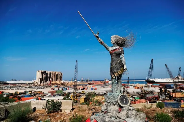 A statue of a woman made out of glass and rubble that resulted from the Beirut port mega explosion August 04, is placed opposite to the site of the blast in the Lebanese capital's harbour to mark the one year anniversary of the beginning of the anti-government protest movement across the country on October 20, 2020. Hundreds marched in Beirut on the weekend to mark the first anniversary of a non-sectarian protest movement that has rocked the political elite but has yet to achieve its goal of sweeping reform. (Photo by Joseph Eid/AFP Photo)