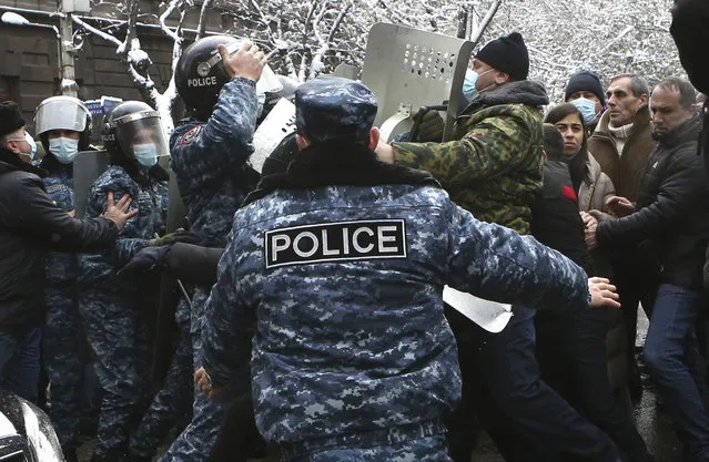 Demonstrators scuffle with Armenian police during a rally to pressure Armenian Prime Minister Nikol Pashinyan to resign over a peace deal with neighboring Azerbaijan on Republic Square in Yerevan, Armenia, Thursday, December 24, 2020. Armenian opposition politicians and their supporters have been protesting for weeks, demanding the prime minister's resignation over his handling of the Nagorno-Karabakh conflict with Azerbaijan. (Photo by Vahram Baghdasaryan, Photolure via AP Photo)