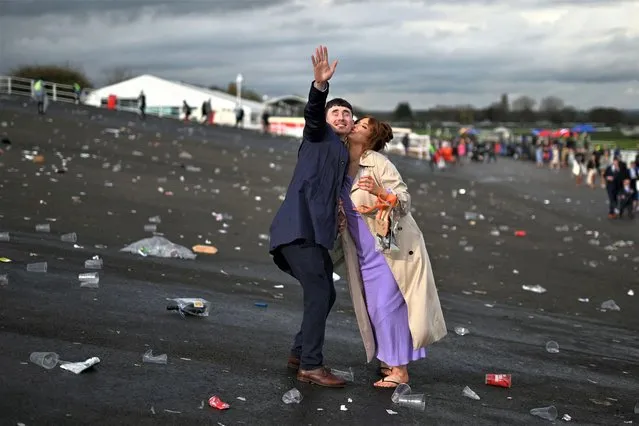 A racegoer steals a kiss at the end of the second day of the Grand National Festival horse race meeting at Aintree Racecourse in Liverpool, north-west England, on April 14, 2023. (Photo by Oli Scarff/AFP Photo)