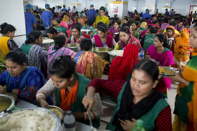 In this April 19, 2018 photo, Bangladeshi garment workers eat their free lunch at Snowtex garment factory in Dhamrai, near Dhaka, Bangladesh. (Photo by A.M. Ahad/AP Photo)