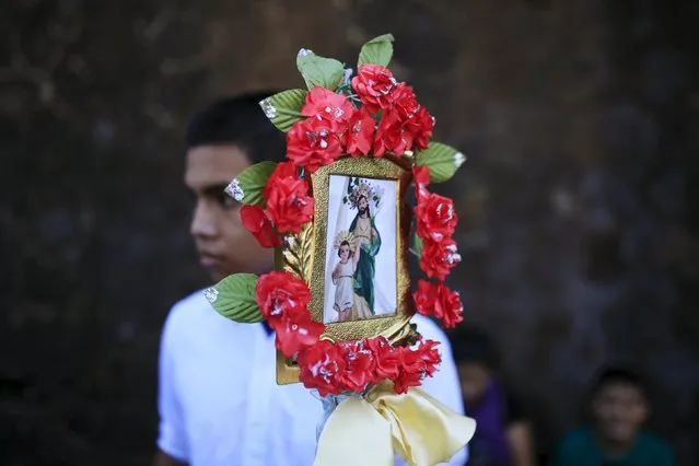 A Catholic devotee known as "Cumpas" carries a standard of the broherhood of Saint Joseph during a pilgrimage in the town of Cuishnahuat, El Salvador November 26, 2015. (Photo by Jose Cabezas/Reuters)