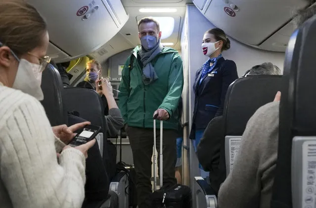 Alexei Navalny and his wife Yulia board the plane prior to flight to Moscow in the Airport Berlin Brandenburg (BER) in Schoenefeld, near Berlin, Germany, Sunday, January 17, 2021. Russian opposition leader Alexei Navalny was arrested Sunday at a Moscow airport as he tried to enter the country from Germany, where he had spent five months recovering from nerve agent poisoning that he blames on the Kremlin. (Photo by Mstyslav Chernov/AP Photo)