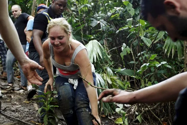 A Cuban migrant smiles as she climbs down a slope after she crossed the border from Colombia through the jungle into La Miel, in the province of Guna Yala, Panama November 29, 2015. (Photo by Carlos Jasso/Reuters)