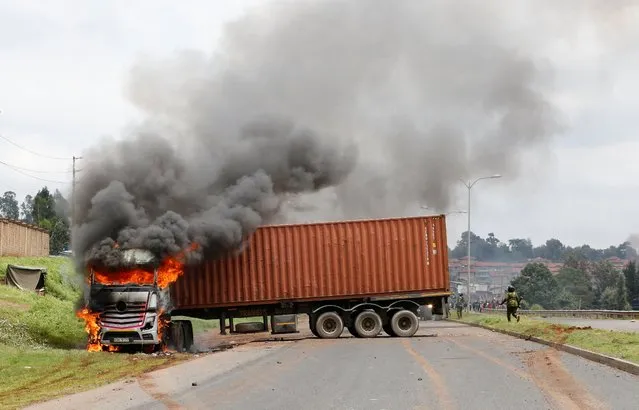 A transit truck burns after it was attacked by unknown people during protests by supporters of Kenya's opposition leader Raila Odinga of the Azimio La Umoja (Declaration of Unity) One Kenya Alliance, in a nationwide protest over cost of living and President William Ruto's government in Nairobi, Kenya on May 2, 2023. (Photo by Thomas Mukoya/Reuters)