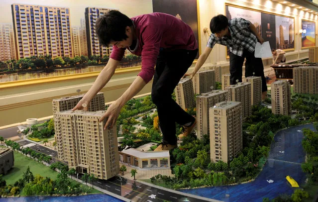 Employees set up model apartments as they prepare a real estate exhibition in Hangzhou, Zhejiang province May 17, 2012. (Photo by Lang Lang/Reuters)