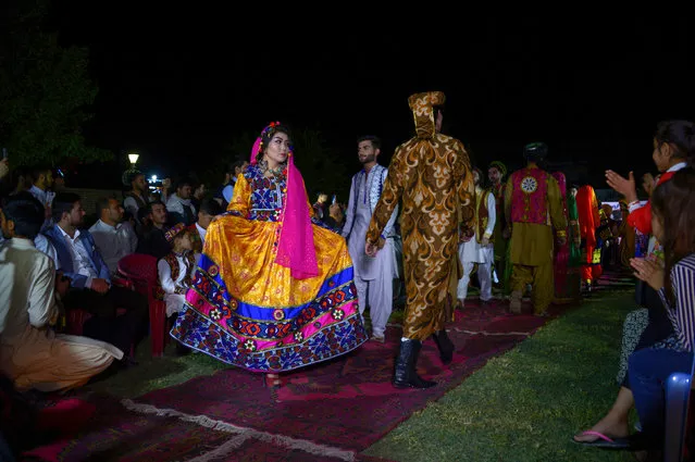 This photograph taken on April 10, 2018 shows Afghan models displaying their outfits at the first Afghan cultural fashion show at an amusement park in Mazar-i-Sharif. Afghanistan remains one of the most dangerous countries for women, with new generations of girls showing courage to bring positive social changes with all the possible risks in such a conservative society. (Photo by Farshad Usyan/AFP Photo)