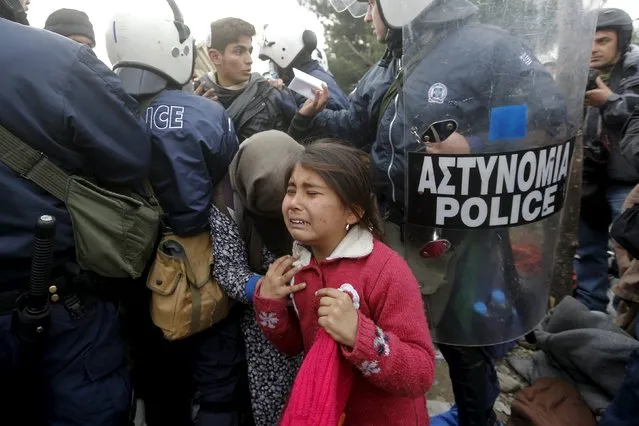 A refugee girl cries after passing through a Greek police cordon before crossing the Greek-Macedonian border near the village of Idomeni, Greece December 4, 2015. (Photo by Yannis Behrakis/Reuters)
