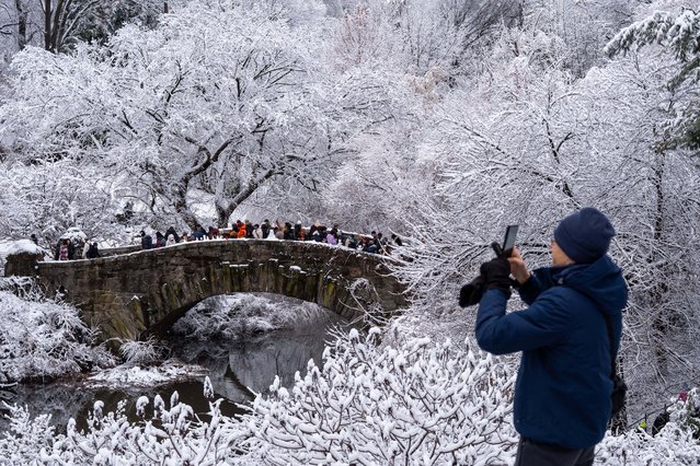 A person takes a photo in Central Park after snow fall, Sunday, December 14, 2025, in New York. (Phopto by Adam Gray)/AP Photo)