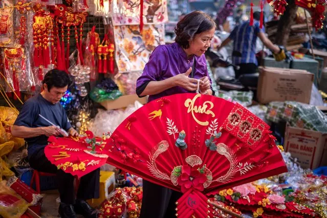Vendors prepare their Lunar New Year decoration items at the Spring Festival Fair in the Old Quarter on January 14, 2023 in Hanoi, Vietnam. (Photo by Linh Pham/Getty Images)