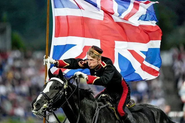A British rider of the Household Cavalry gallops with the Union Flag during the opening ceremony of the CHIO Equestrian Festival in Aachen, Germany, Tuesday, June 27, 2023. Britain is this year's partner country of the most important international Jumping, Dressage, Four-in Hand Driving and Vaulting horse meeting. (Photo by Martin Meissner/AP Photo)