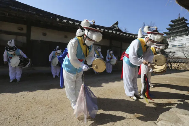 South Korean traditional band members wearing face masks as a precaution against the coronavirus pray during a ceremony to celebrate Jeongwol Daeboreum, or Great Full Moon Day, the first full moon of the Lunar New year, at the National Folk Museum of Korea in Seoul, South Korea, Friday, February 26, 2021. (Photo by Ahn Young-joon/AP Photo)
