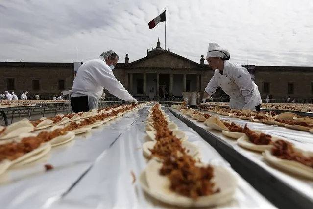 Chefs prepare tacos of Cochinita Pibil, a popular dish from Yucatan, in an attempt to break the Guinness World Record for the world's longest taco in Guadalajara February 15, 2015. (Photo by Alejandro Acosta/Reuters)