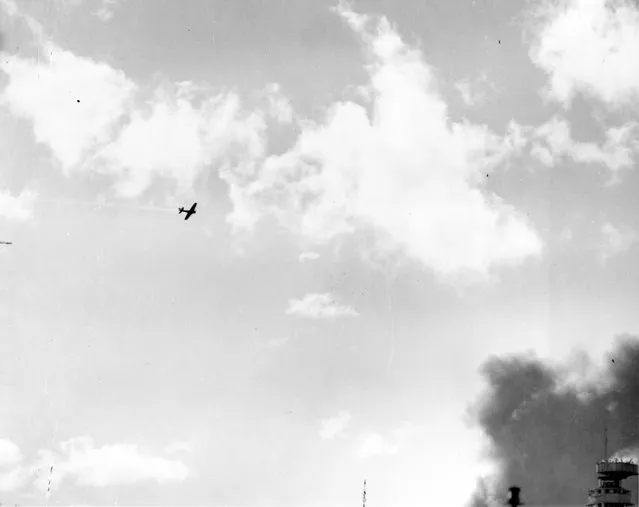 A Japanese Type 00 (Zero) carrier fighter trails smoke after it was hit by anti-aircraft fire during the attack on Pearl Harbor, Hawaii, U.S. December 7, 1941. (Photo by Reuters/U.S. Navy/National Archives)