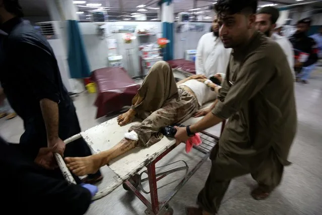 An injured man is shifted to a hospital following a blast targeting a gathering of Islamic political party Jamiat Ulma-e-Islam (JUI-F), in Peshawar, Pakistan, 30 July 2023. At least 40 people were killed and several injured in an explosion at the JUI-F workers convention in Khar, police said. (Photo by Arshad Arbab/EPA)