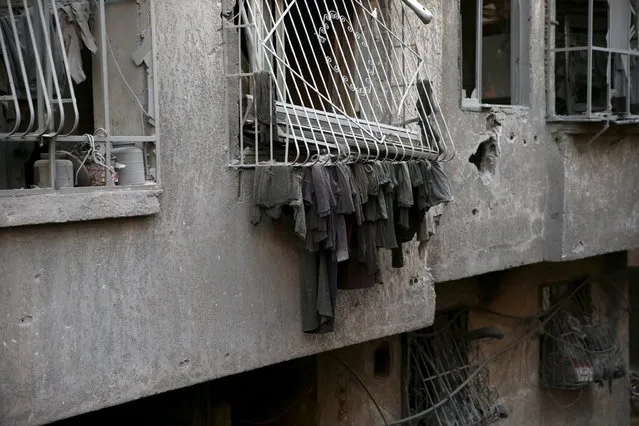 Dust-covered laundry hangs in a damaged site hit by what activists said were airstrikes carried out by the Russian air force in the town of Douma, eastern Ghouta in Damascus, Syria January 10, 2016. (Photo by Bassam Khabieh/Reuters)