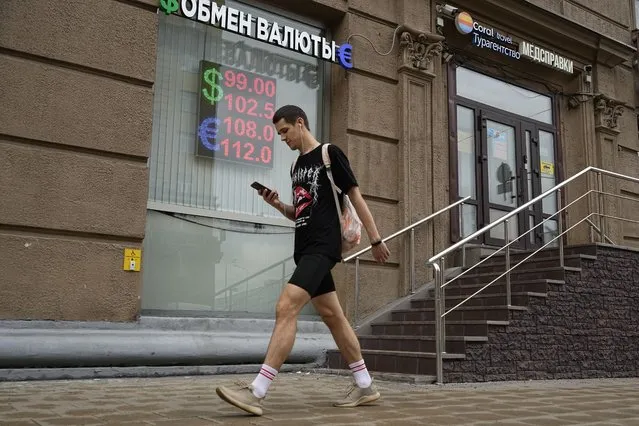 A man walks past a currency exchange office in Moscow, Russia, Monday, August 14, 2023. The Russian ruble has reached its lowest value since the early weeks of the war in Ukraine as Western sanctions weigh on energy exports and weaken demand for the national currency. The Russian currency passed 101 rubles to the dollar on Monday, continuing a more than 25% decline in its value since the beginning of the year. (Photo by Alexander Zemlianichenko/AP Photo)